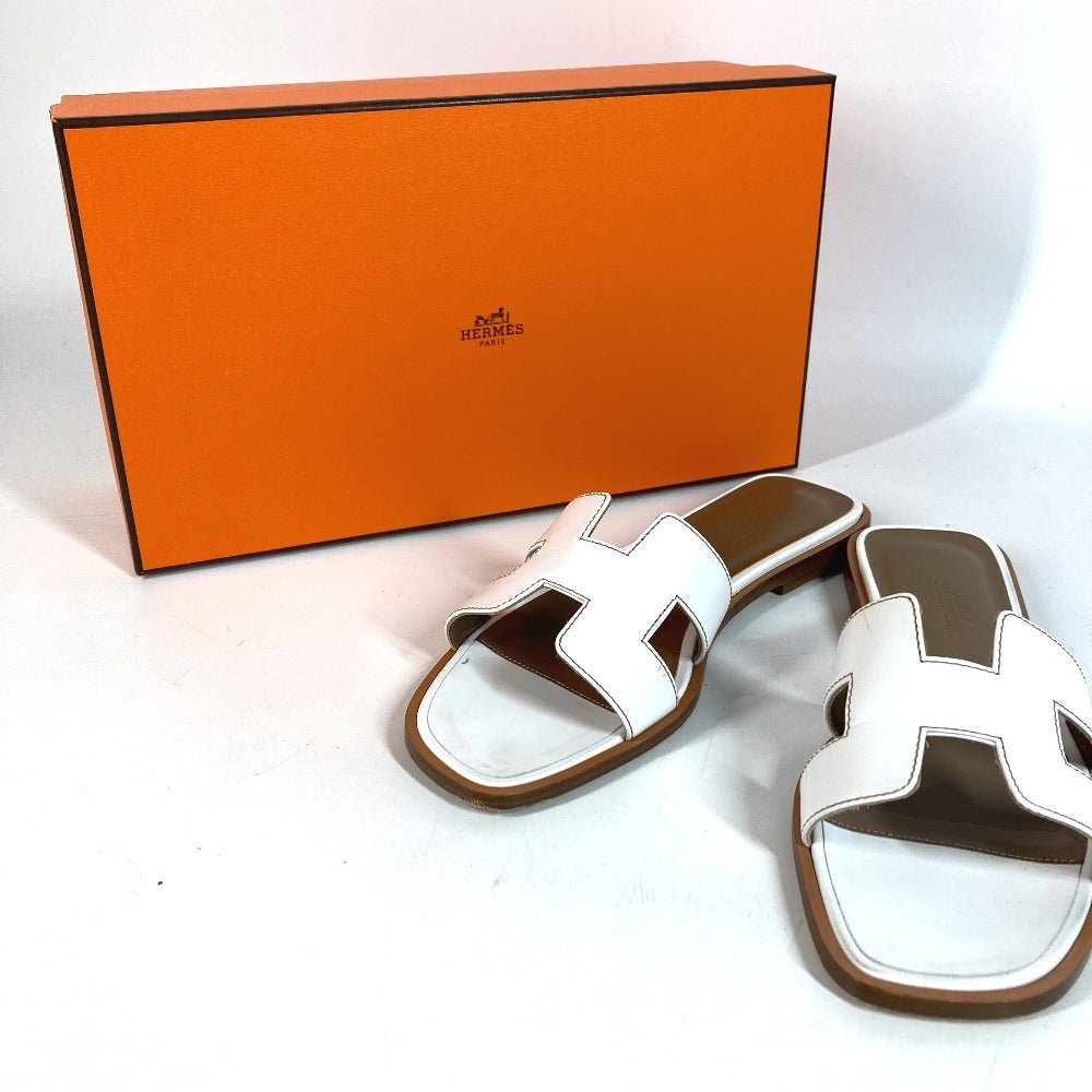 HERMES Oran H-Logo รองเท้าแตะแฟลตหนังสีขาวสำหรับผู้หญิง