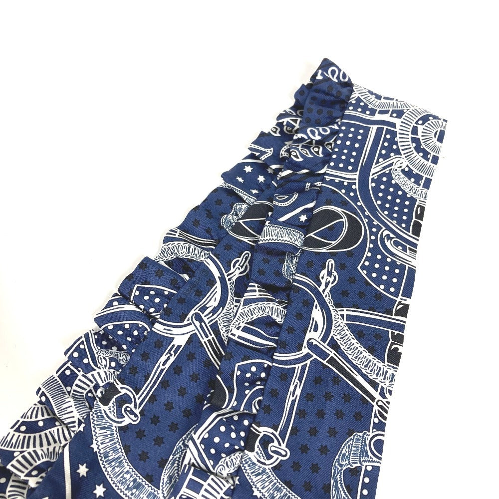 HERMES Apron d'Or, a silk scarf with a ruffled twilly lining, available in Marine Foncé, black, white, and blue.
