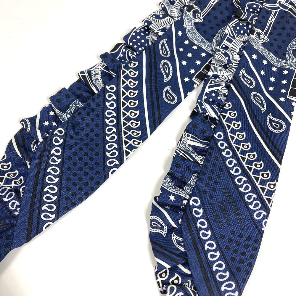 HERMES Apron d'Or, a silk scarf with a ruffled twilly lining, available in Marine Foncé, black, white, and blue.