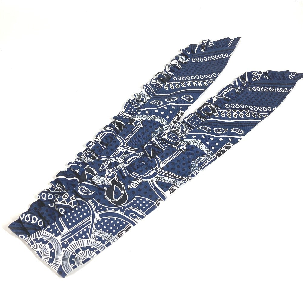 HERMES Apron d'Or, a silk scarf with a ruffled twilly lining, available in Marine Foncé, black, white, and blue.