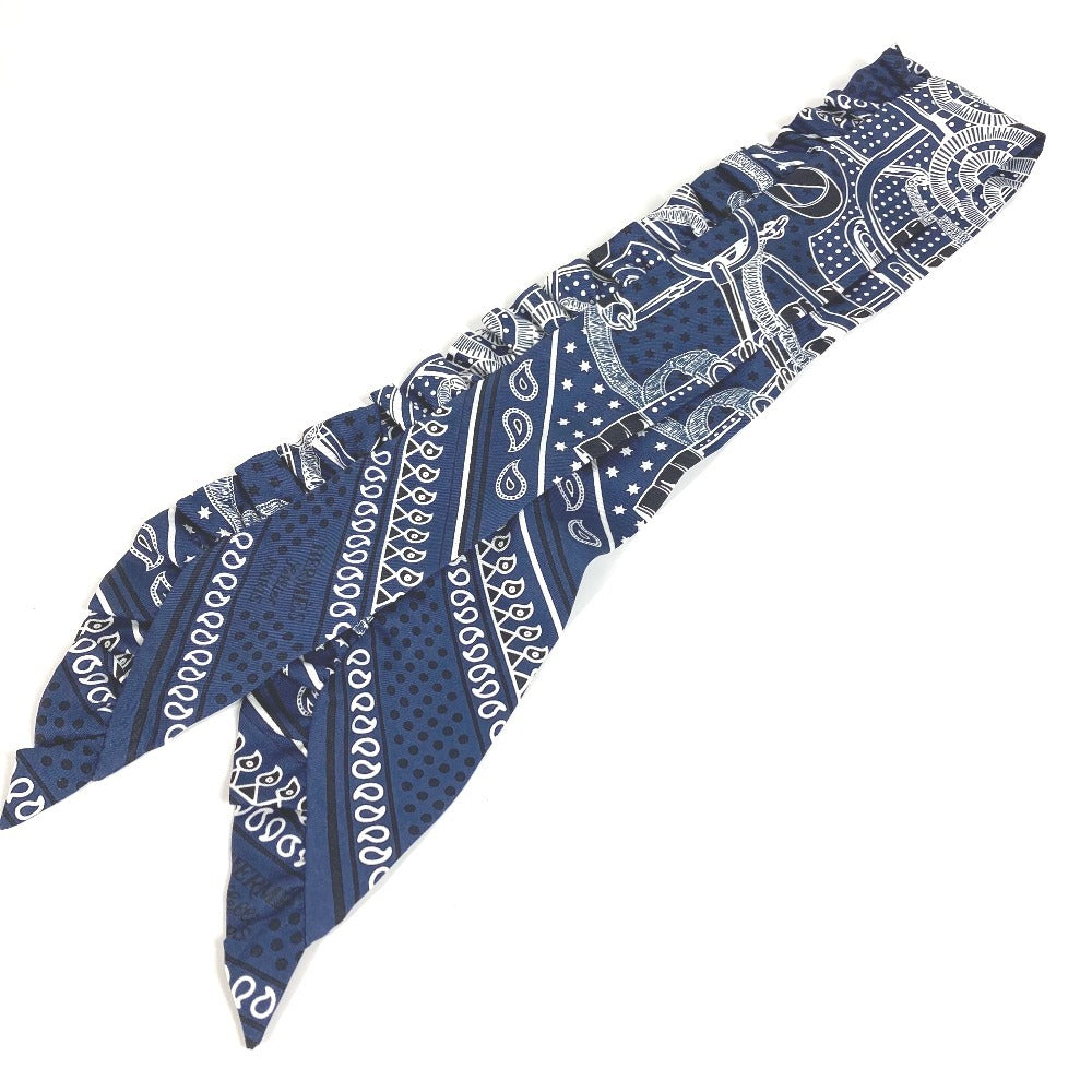 HERMES Apron d'Or, a silk scarf with a ruffled twilly lining, available in Marine Foncé, black, white, and blue.