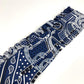 HERMES Apron d'Or, a silk scarf with a ruffled twilly lining, available in Marine Foncé, black, white, and blue.
