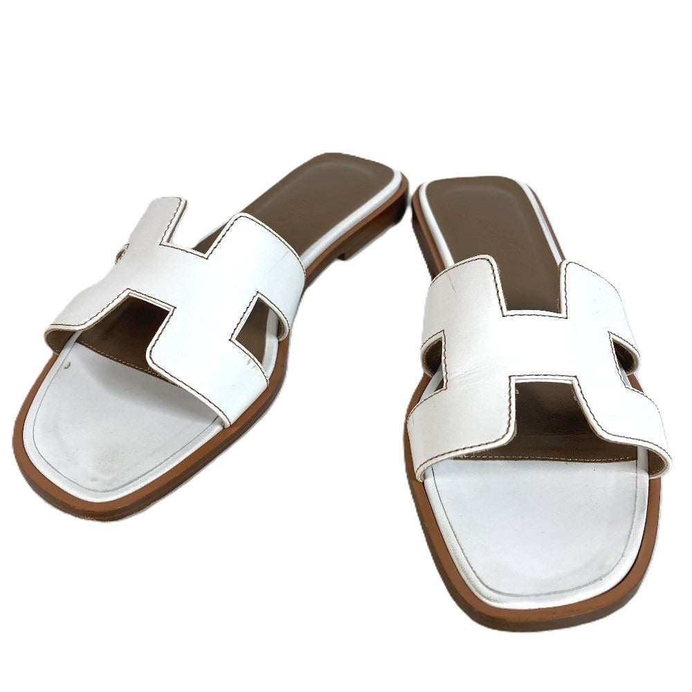 HERMES Oran H-Logo รองเท้าแตะแฟลตหนังสีขาวสำหรับผู้หญิง
