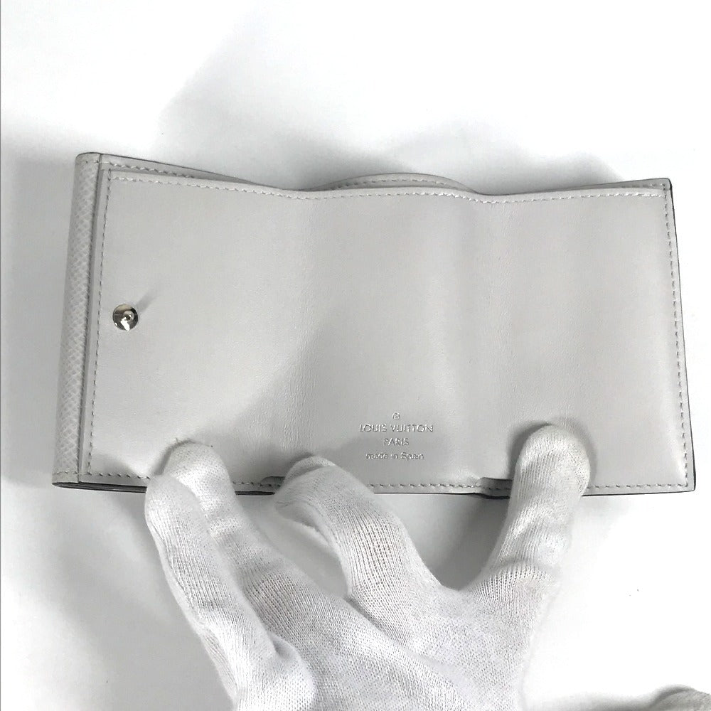 LOUIS VUITTON M67621 Taiga Rama Discovery Compact Wallet, a tri-fold wallet in Taiga leather, unisex, in blanc and white.